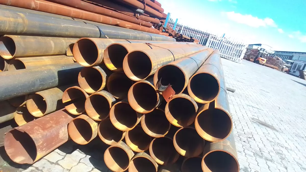 Large metal pipes stacked in an industrial yard