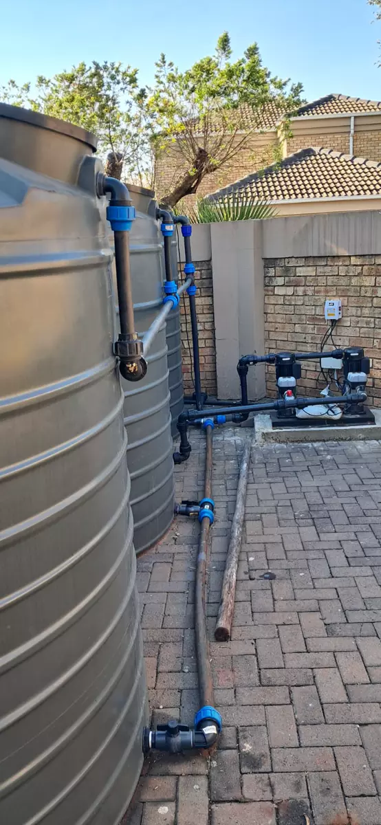 Large grey water storage tanks with plumbing and pumps