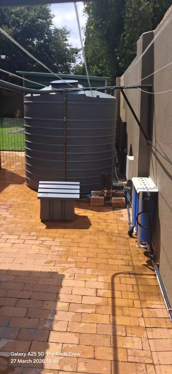 Water storage tank and filtration system in a paved yard