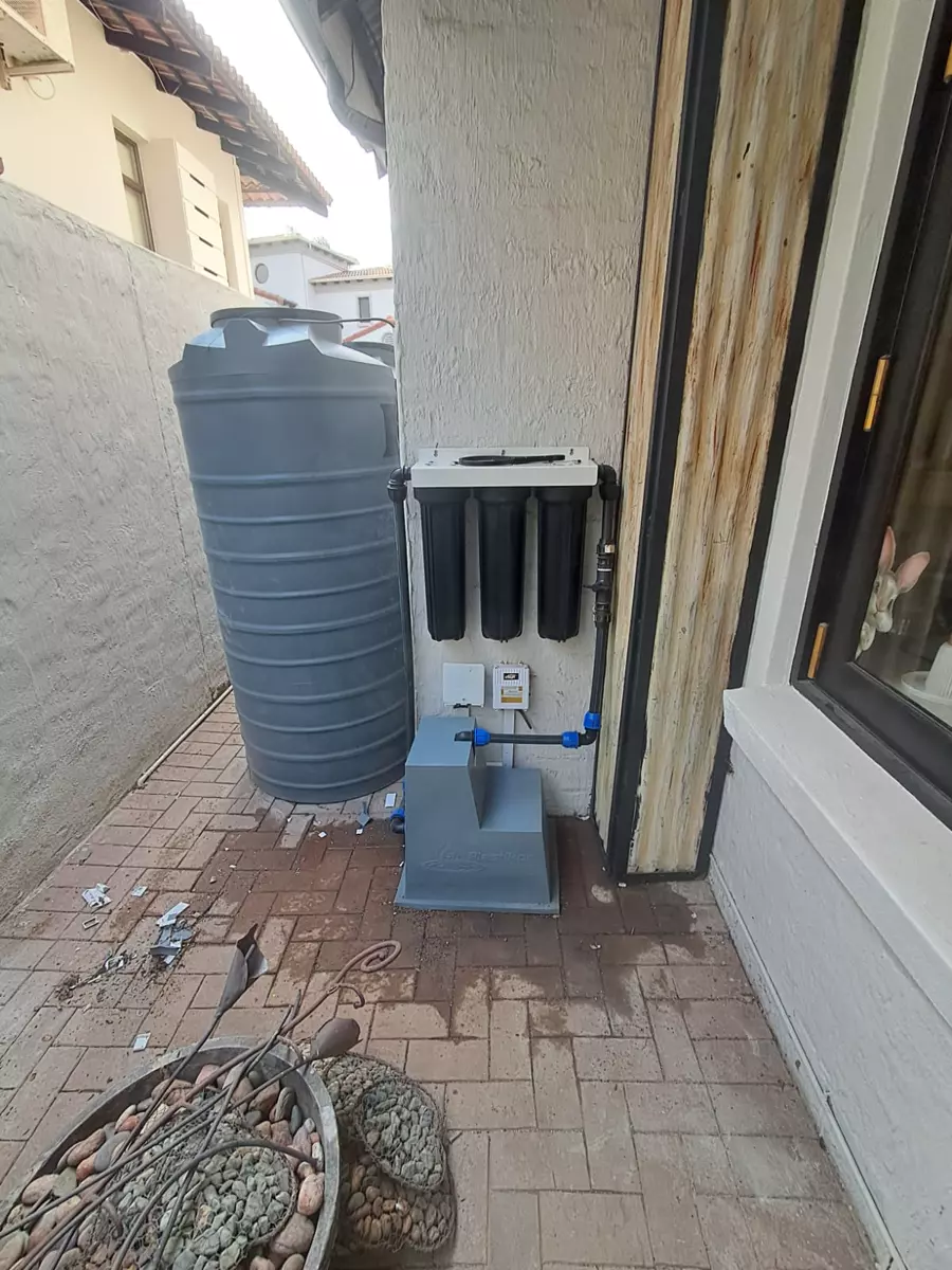 Water filtration system and storage tank installed outdoors