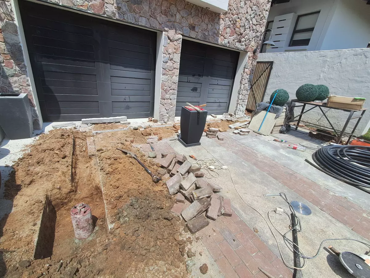 Driveway under construction with excavated soil and bricks