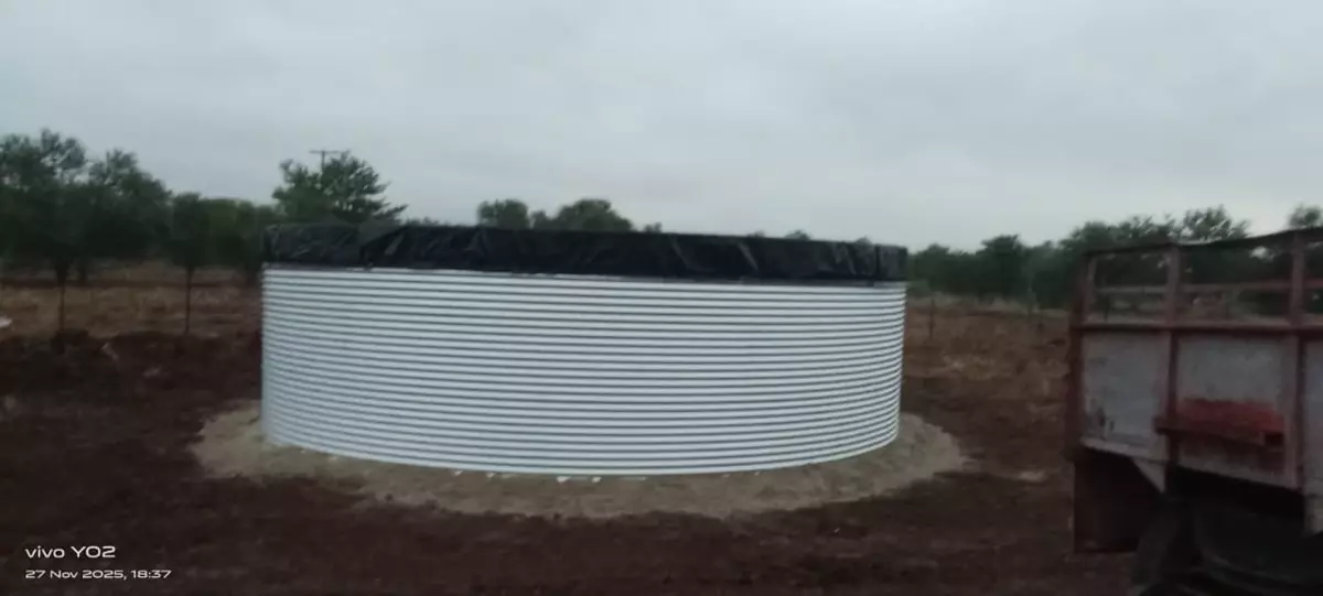 Corrugated metal water tank in a rural field