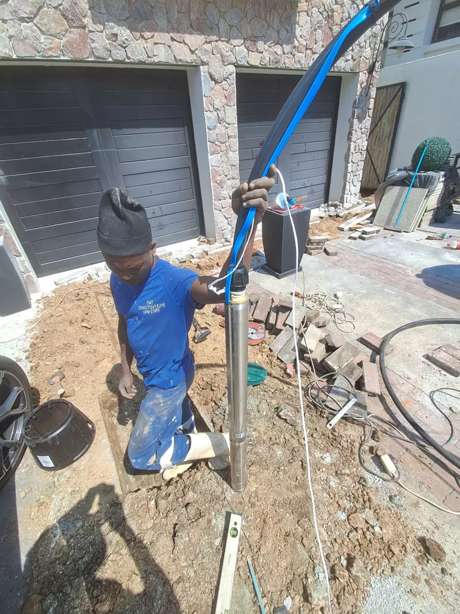 Worker holding a submersible borehole pump